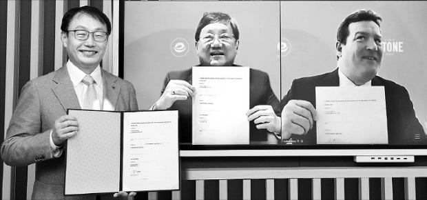 구현모 KT 대표(왼쪽)와 이안 쿠옥 쿠옥그룹 회장(가운데) 등이 지난 8일 온라인 화상회의를 통해 주식매매계약을 체결한 뒤 계약서를 들어보이고 있다.  KT  제공