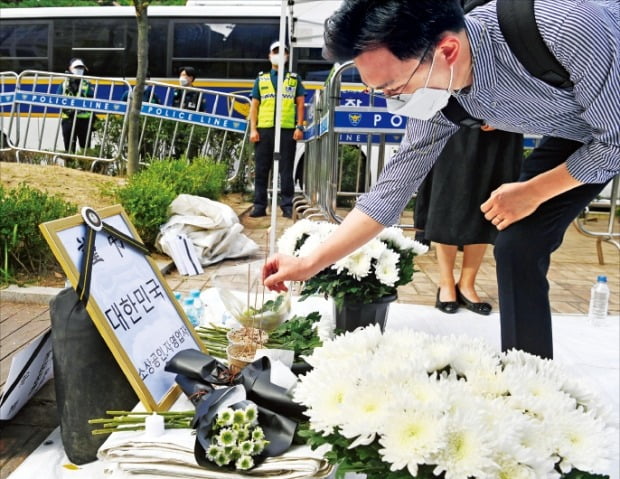 17일 서울 여의도 국회 앞에 차려진 자영업자들을 위한 합동분향소를 찾은 한 시민이 향을 피우고 있다.  /연합뉴스 