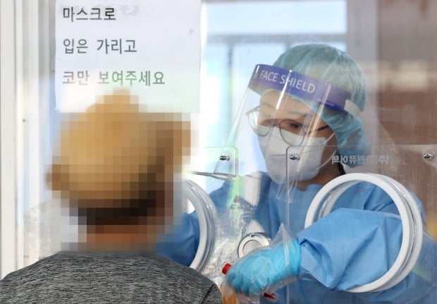 추석 연휴 뒤 첫 날인 지난 23일 오전 서울 중구 서울역광장에 설치된 임시 선별검사소에서 의료진이 검체를 채취하고 있다. 사진=연합뉴스