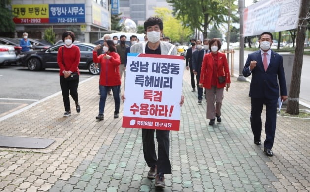 국민의힘 대구시당 당직자들이 13일 시당 당사 앞에서 대장동 특혜의혹에 대한 특검을 촉구하며 동대구역까지 거리 행진을 하고 있다. 연합뉴스