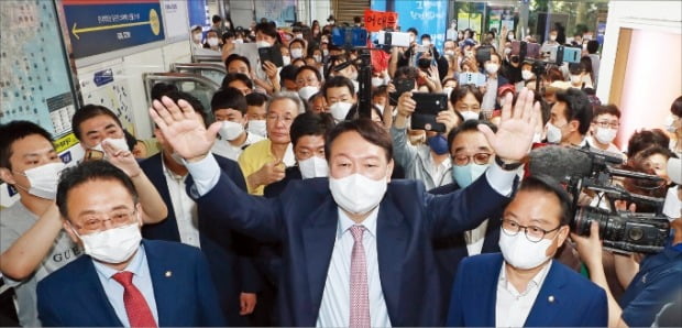 < 尹, 부산 지하상가 찾아 > 국민의힘 대선주자인 윤석열 전 검찰총장(가운데)이 4일 부산 서면지하상가를 찾아 지지자들을 향해 손을 들어 인사하고 있다.  연합뉴스 