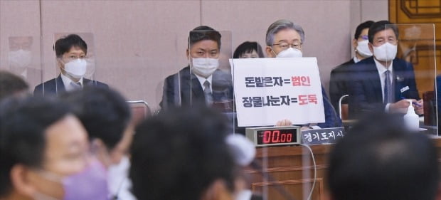 이재명 더불어민주당 대선후보가 18일 경기도청에서 열린 국회 행정안전위원회의 경기도 국정감사에서 ‘돈받은자=범인, 장물나눈자=도둑’이란 손팻말을 들고 의원들의 질의에 답하고 있다. /김병언  기자 