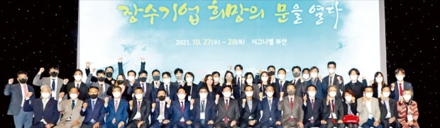 27일 시그니엘 부산에서 중소기업중앙회와 기업은행이 주관하고 한국경제신문사가 후원한 2021 장수기업 희망포럼 ‘장수기업 희망의 문을 열다’가 열렸다. 기업승계 전문가들의 특별 토론회를 비롯해 1·2세대 중소기업인 50여 명이 참석해 기업승계에 대한 의견을 공유하고 관계망을 다졌다. 포럼에 참석한 관계자들이 기념촬영을 하고 있다.  /중기중앙회  제공 