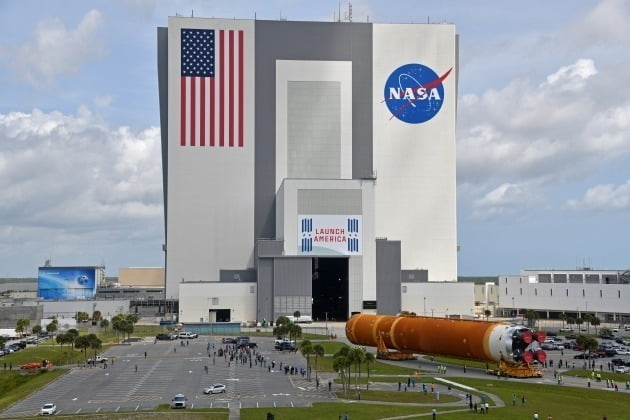 지난 4월 29일 1972년 아폴로 17호 이후 중단된 미국의 유인 달 탐사의 부활을 알리는 아르테미스 프로젝트에 사용될 우주 발사체 SLS가 플로리다 케네디 우주센터의 조립동으로 운송되고 있다. NASA는 올해와 내년 두 차례 시험 발사를 거쳐 2024년 사람을 다시 달에 보내고 2028년부터는 상주 기지를 운영하는 것이 목표다. /연합뉴스