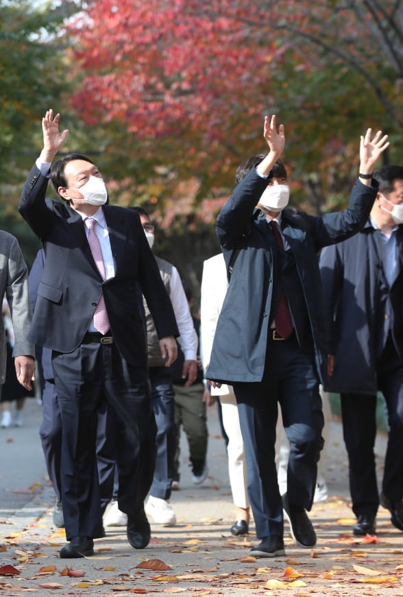 이준석 국민의힘 대표와 윤석열 대선 후보가 6일 오후 오찬을 위해 서울 마포구 염리동 한 식당으로 이동하며 시민들에게 손을 들어 인사하고 있다. 2021.11.6 [사진=연합뉴스]