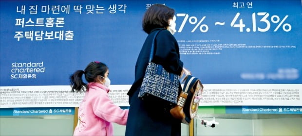 은행의 대출금리 상승폭이 한국은행 기준금리 인상폭을 크게 웃돌면서 차입자들의 불만이 커지고 있다. 한 모녀가 26일 대출상품 현수막이 내걸린 서울의 한 은행 앞을 지나가고 있다. /허문찬 기자 