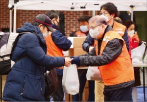 지난 1월 ‘명동밥집’에서 염수정 추기경(오른쪽)이 한 노인에게 도시락을 나눠주고 있다.  /천주교 한마음한몸운동본부 제공 