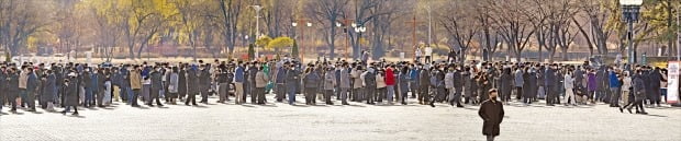 < 주말에도 줄지 않는 코로나 검사 행렬 > 12일 서울 월드컵공원 평화광장에 마련된 임시선별검사소가 검사를 기다리는 시민들로 가득하다. 중앙방역대책본부에 따르면 11일 기준 위중증 환자는 894명으로, 종전 최다치인 9일 857명보다 37명 늘었다. 위중증 환자가 급증하면서 병상 부족 사태도 심각해지고 있다. 수도권에서 병상이 없어 대기 중인 코로나19 확진자는 1739명에 달한다.  연합뉴스 