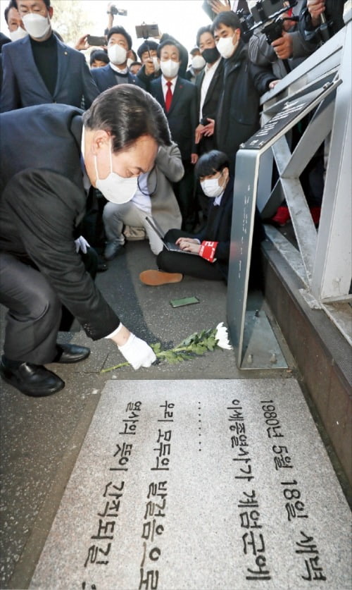 < “반대 의견도 듣겠다” > 윤석열 국민의힘 대선 후보가 22일 전주 전북대에 있는 이세종 열사 표지석 앞에서 헌화하고 있다. 윤 후보는 당초 추모비에 헌화하려고 했으나 5·18 단체들이 막아서면서 표지석까지만 접근할 수 있었다.   /연합뉴스 