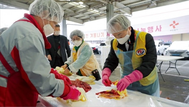 박상돈 천안시장(오른쪽)이 자원봉사자와 김장나눔 행사에 참여해 이웃에게 나눠줄 김치를 담그고 있다. /천안시 제공
 