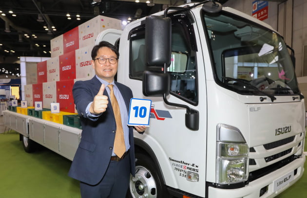 김석주 큐로모터스 대표가 이스즈의 2.5톤 상용트럭 '엘프' 앞에서 기념사진을 찍고 있다. 사진=큐로모터스