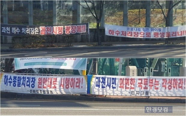 과천 하수처리장 부지 선정에 반대하는 서초구 현수막(위)과 원안 고수를 요구하는 과천 현수막. 사진=오세성 한경닷컴 기자