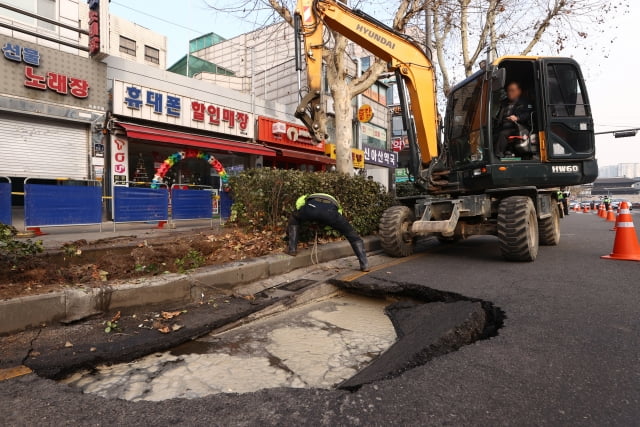 23일 싱크홀(지반 침하) 현상이 발생한 서울 종로구 종로5가역 인근 도로에서 관계자들이 복구작업을 하고 있다. 사진=연합뉴스