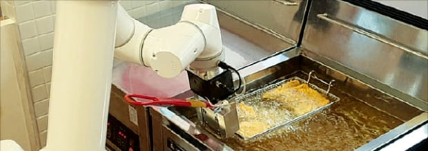푸드테크 스타트업 로보아르테가 개발한 로봇팔이 치킨을 자동으로 튀기고 있다.  로보아르테  제공 