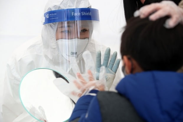  8일 오전 대구 수성구보건소 선별진료소에서 방역복 차림의 근무자가 코로나19 신속항원검사를 앞두고 겁먹은 어린이를 안심시키고 있다. /사진=뉴스1