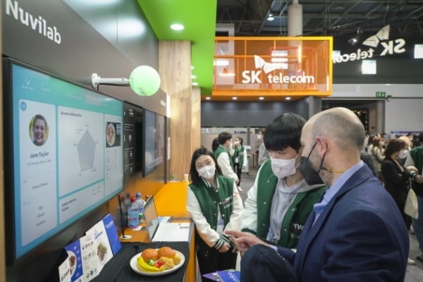 SK텔레콤 누비랩 부스를 방문한 한 MWC 관람객이 음식물 쓰레기를 줄이는 ESG기술에 대해 설명을 듣고 있다.