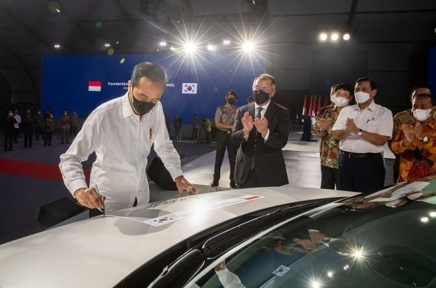 16일 열린 인도네시아 현대차 공장 준공식에서 조코 위도도 인도네시아 대통령(왼쪽)이 아이오닉5 차량에 서명을 하고 있는 모습. 정의선 현대차그룹 회장(가운데 검정색 마스크)이 박수를 치고 있다. /사진=현대차 제공