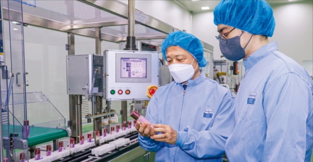최현규 한국콜마 대표(왼쪽)가 인공지능 활용 자동화 시스템을 적용한 세종공장에서 제품을 살펴보고 있다.  한국콜마  제공 