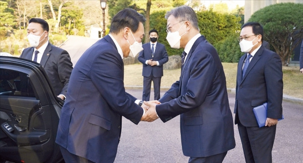 문재인 대통령이 28일 만찬 회동을 위해 청와대에 도착한 윤석열 대통령 당선인과 악수하고 있다. 문 대통령은 이날 이례적으로 여민관 1층까지 나와 윤 당선인을 맞이했다.  /청와대 제공 