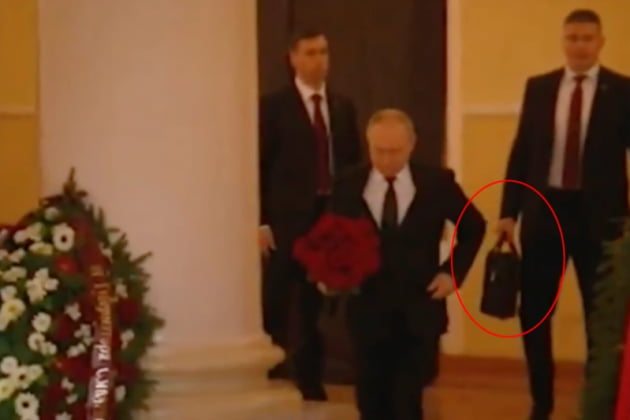 푸틴 대통령 뒤로 한 경호원이 '핵가방'으로 추정되는 가방을 들고 있다. 사진=영국 매체 더선