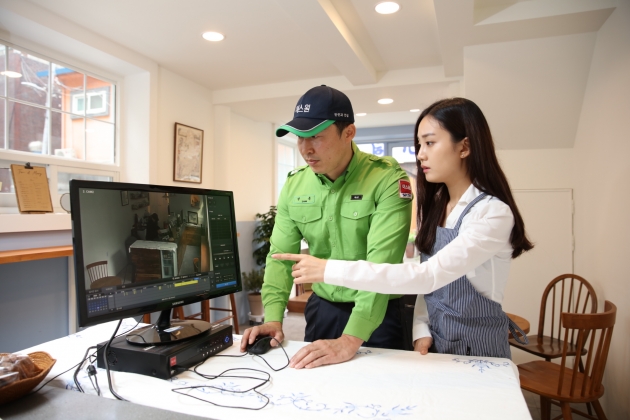 무인매장 점주(오른쪽)가 에스원 보안요원과 함께 CCTV를 통해 매장 내부를 살펴보고 있다. 