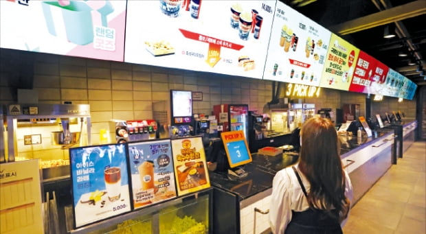 22일 서울 CGV용산아이파크몰점을 찾은 손님이 매점을 둘러보고 있다. 정부는 오는 25일부터 영화관에서 음식 섭취를 허용했다.    연합뉴스 