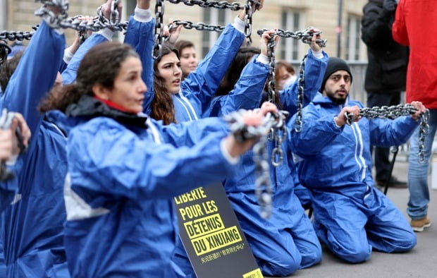 지난 1월 프랑스 파리의 의회 앞에서 국제인권단체 국제사면위원회(AI) 활동가들이 쇠사슬로 자신들의 손을 묶은 채 중국 정부의 신장 위구르족 인권탄압에 대해 항의하며 시위를 벌이고 있다. /사진=AFP