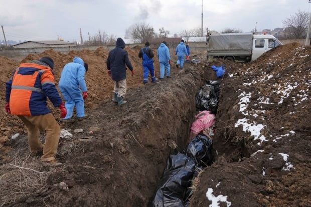 러시아군의 포위 공격을 받은 우크라이나 남부 항구도시 마리우폴 외곽에서 인부들이 포격에 희생된 주민들의 시신을 집단매장하고 있다. /사진=AP