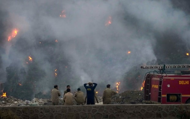 인도 수도 뉴델리의 대규모 쓰레기 매립지에서 난 불을 끄기 위해 출동한 소방관들이 화재 발생 이틀째인 27일(현지시간) 진화에 나설 엄두를 내지 못한 채 현장을 지켜보고 있다. /사진=AP