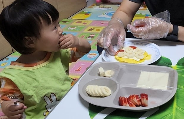 딸기를 한 움큼 쥐고 먹던 딸아이가 상황을 살피듯 눈치를 보고 있습니다.