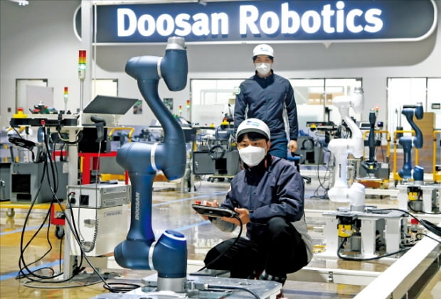 경기 수원시에 있는 두산로보틱스 공장에서 직원들이 출고를 앞둔 협동로봇을 살펴보고 있다. 한경DB
 