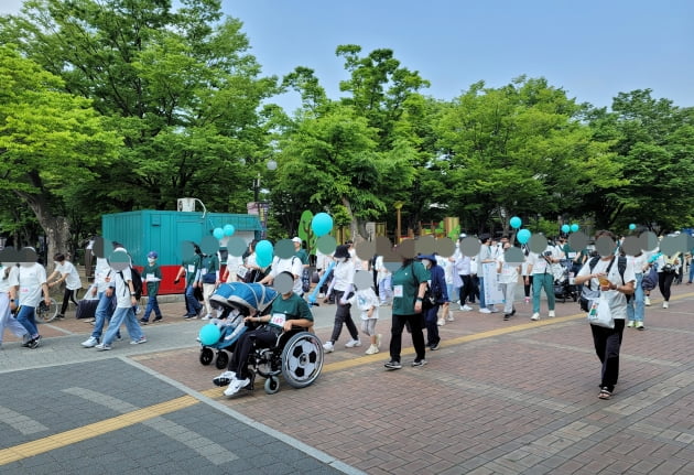 지난 21일 서울 송파구 올림픽공원에서 ‘2022 상상인 피크닉 데이’ 행사가 열렸다. 사진은 ‘휠체어 사용 아동 이동성 향상 프로젝트’ 참여 아동과 가족, 상상인 임직원들이 올림픽공원을 걷고 있는 모습. 사진=김태림 기자