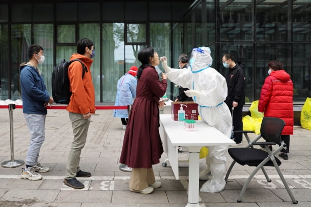 지난 4월 27일 중국 수도 베이징 거리에 설치된 한 코로나19 임시 검사소에서 방호복을 입은 의료진이 검체를 채취하고 있다. (사진=연합뉴스)