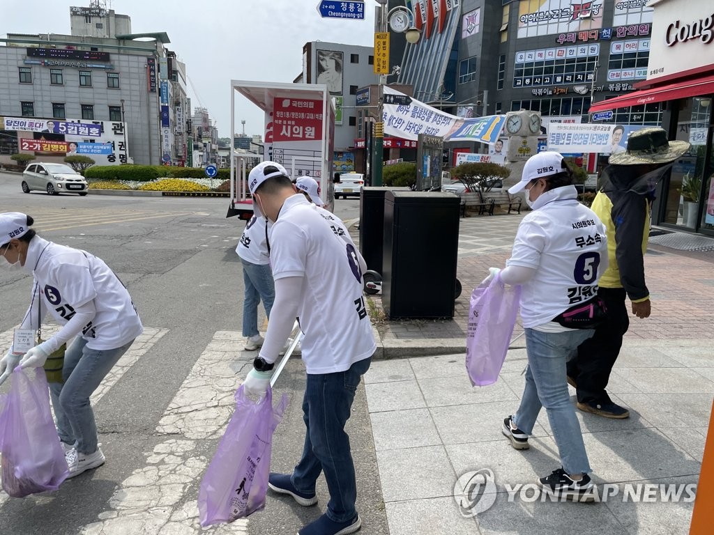 AR 후보가 악수하고, 공룡 인형 옷 입고, 철모 착용도