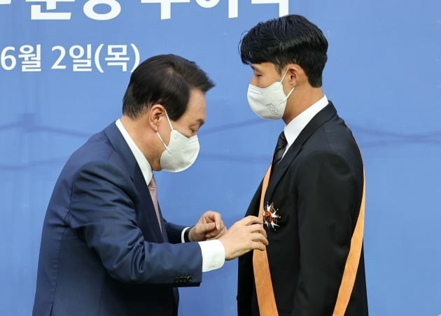 윤석열 대통령이 2일 브라질과의 축구 국가대표팀 친선전을 앞두고 서울 상암월드컵경기장에서 손흥민 선수에게 청룡장을 직접 수여하고 있다. 뉴스1