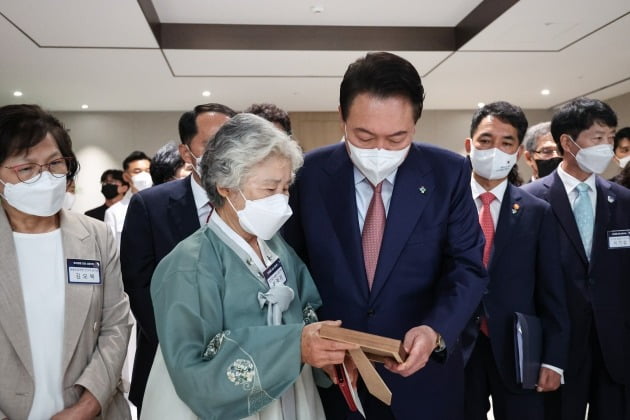 윤석열 대통령과 천안함 희생자 고 민평기 상사 모친 윤청자 여사가 9일 서울 용산 대통령실 청사에서 열린 '호국영웅 초청 소통식탁' 행사에서 아들 민 상사의 사진을 보고 있다. 대통령실 제공