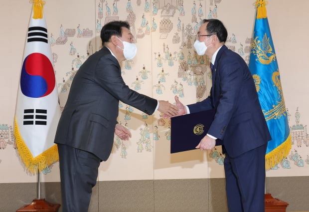 윤석열 대통령이 10일 서울 용산 대통령실 청사에서 김필곤 중앙선거관리위원회 위원에게 임명장을 수여한 뒤 악수를 나누고 있다. 사진=뉴스1