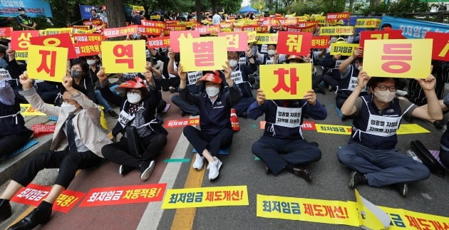 지난 8일 서울 국회의사당역 인근에서 열린 최저임금 제도개선 촉구 소상공인 결의대회에서 참가자들이 손팻말을 흔들고 있다. 연합뉴스