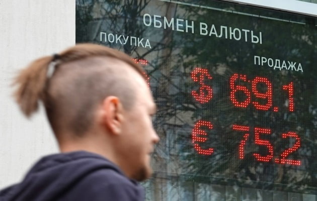 Um homem passa em frente ao preço de mercado de uma casa de câmbio em Moscou, Rússia, no dia 15.  / Notícias Yonhap