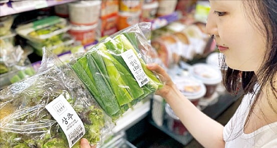 13일 한 소비자가 CU 매장에서 소포장 채소 ‘싱싱생생’을 살펴보고 있다.  BGF리테일 제공 