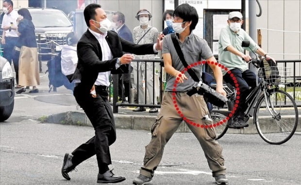 8일 일본 나라시 야마토사이다이지역 인근에서 경찰이 아베 신조 전 일본 총리에게 총을 쏜 용의자 야마가미 데쓰야(41)를 제압하고 있다. 빨간 원 안에 용의자가 개조한 총이 보인다. /게티이미지