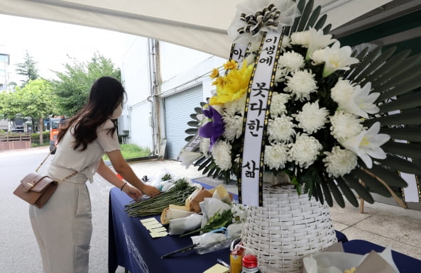 인하대학교 캠퍼스에서 같은 학교 재학생을 성폭행한 뒤 건물에서 추락해 숨지게 한 사건이 발생한 가운데 17일 오전 인천광역시 인하로 인하대학교에 마련된 분향소에서 한 학생이 헌화를 하고 있다. 2022.7.17/뉴스1