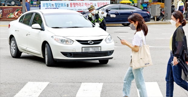 교통경찰이 12일 서울 대학로에서 ‘교차로 우회전 시 일시정지 후 통행’ 위반 차량을 대상으로 계도 활동을 하고 있다. 이날부터 시행된 개정 도로교통법에 따르면 우회전 차량은 보행자가 횡단보도를 통행하는 때는 물론 ‘통행하려고 할 때’도 일시정지해야 한다. 어린이보호구역에선 보행자와 관계없이 반드시 멈춰야 한다.   김병언  기자 