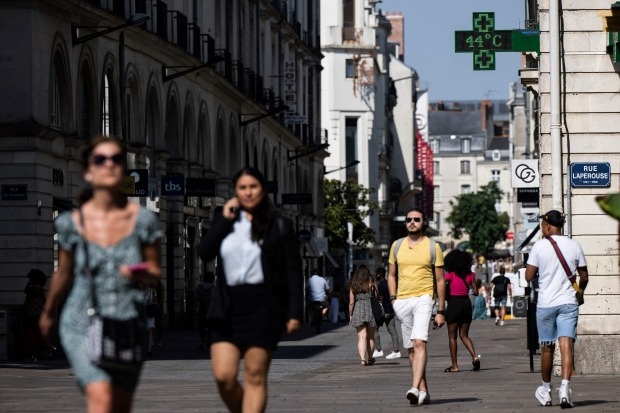 Pedestrians walk through the streets as the temperature indicating 44 degrees Celsius is displayed on a sign at a pharmacy in Nantes, western France, on the 18th (local time).  /photo = AFP