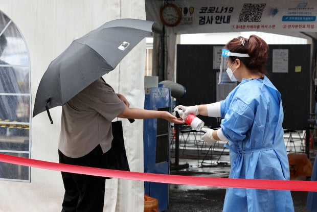 코로나19 선별진료소에서 의료진이 손소독제를 뿌려주고 있다. 사진=연합뉴스