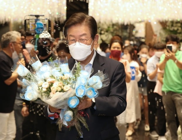 이재명 더불어민주당 의원이 4일 울산 남구 엑소21컨벤션에서 열린 '울산 당원 및 지지자와의 만남'에서 지지자들로부터 장미꽃을 받고 있다. 뉴스1