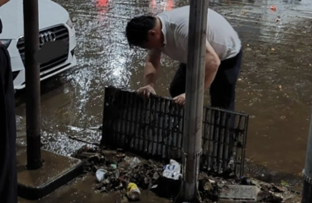 강남역에서 배수관 덮개를 열어 물길을 막고 있던 쓰레기를 주운 시민 /사진=온라인 커뮤니티