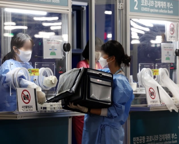 지난 29일 오전 인천공항 제2터미널 코로나 검사센터에서 의료진이 검체를 옮기고 있다. 사진=연합뉴스