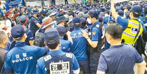 민주노총 화물연대가 5일 홍천군 하이트진로 강원공장에서 맥주 수송 차량에 돌을 던지는 등 과격 시위를 벌였다. 이날 경찰과 시위대가 공장 앞에서 몸싸움을 벌이고 있다.    하이트진로 강원공장  제공 