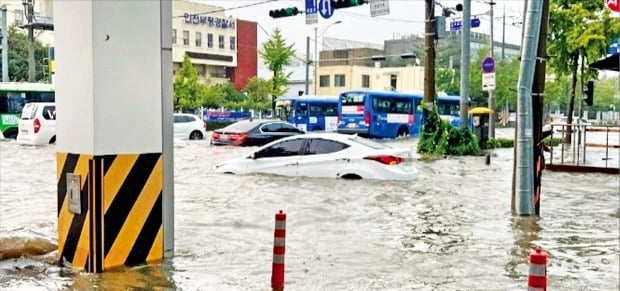 < 기습 폭우에 물에 잠긴 인천 > 8일 인천 부평경찰서 인근 도로가 기습 폭우로 침수되면서 주차돼 있던 차량들이 반쯤 물에 잠겨 있다. 이날 인천 내륙지역에는 시간당 80㎜의 폭우가 쏟아져 호우경보가 발령됐다.   연합뉴스 